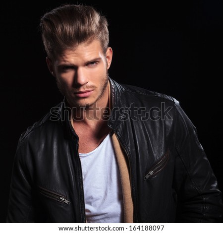 portrait of a young fashion man in leather jacket looking at the camera