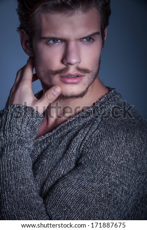 face of a dramatic beauty male model looking away while posing in studio