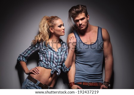 woman leaning against her boyfriend and looks at his while he looks at the camera