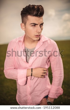 side view of a casual young man in the outdoors, looking away from the camera
