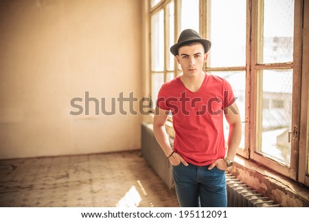 casual young man standing in an old dirty room