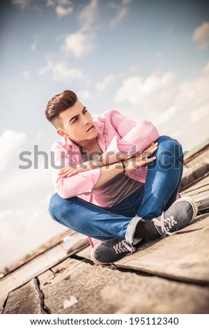 seated young man bitting his lip in a provocative pose