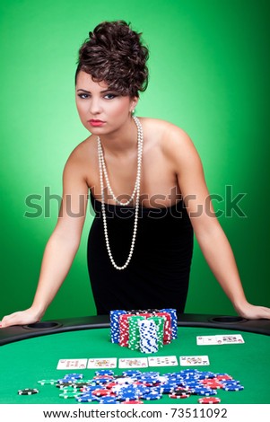 casino woman standing against poker table near her hearts royal flush