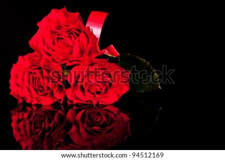 Picture of three roses on black background . Flowers on reflective black background