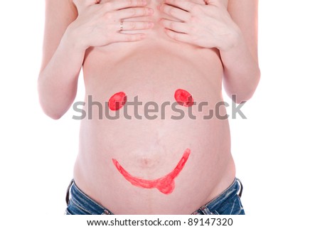 Painted red smiley face on the belly of pregnant woman