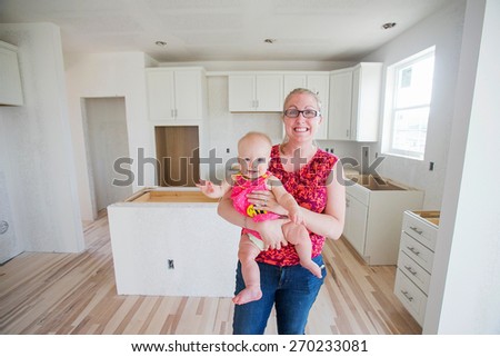 Mother and baby in new home construction kitchen remodel