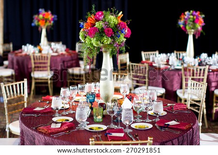 Centerpieces made of Roses, Asparagus fern, Delphinium, Asiatic lilies, Wax flower, Amaranthus, and Springeri at a wedding reception