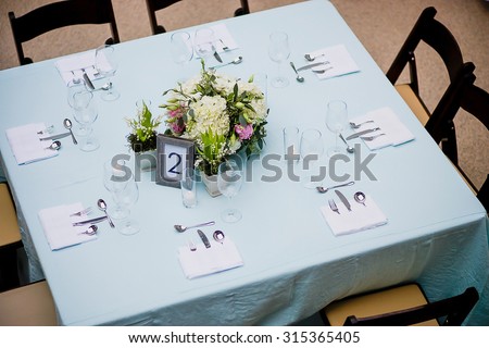 Overhead view of a floral centerpiece on a square table at a formal event