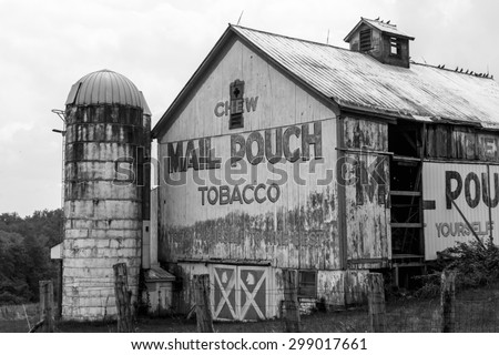 Black and white of old barn in rural Ohio with faded ad painted on side.
