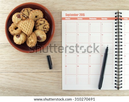 plan book and cookie on wood, each day plan in September