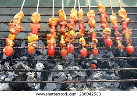Bar-B-Q or BBQ with kebab cooking. coal grill of chicken meat skewers with mushroom and peppers. barbecuing dinner