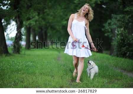 Young woman walking a golden retriever puppy