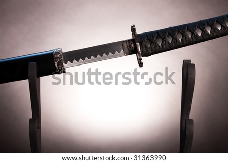 Almost black and white photo of long japanese sword with a naked blade.
