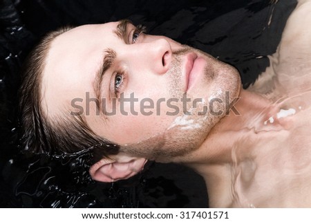 Portrait of an attractive young man in water