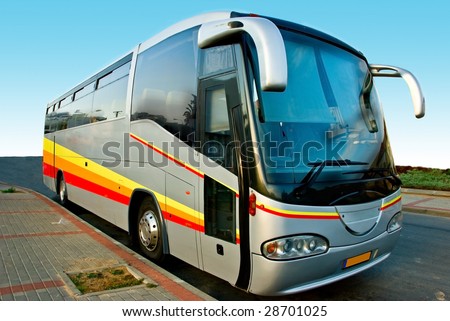 Front view of a big modern tour bus parked by the side of the road