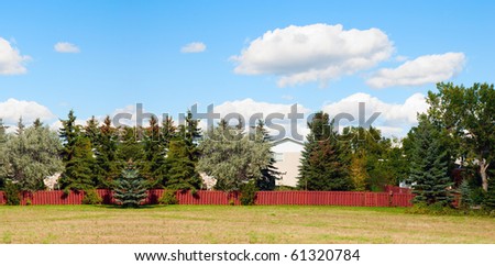 A house hidden behind the big trees. Panorama view.