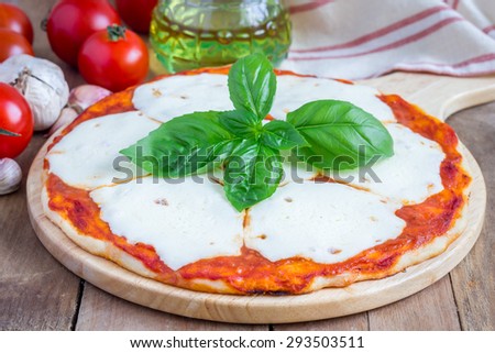 Homemade pizza with mozzarella cheese on a wooden board