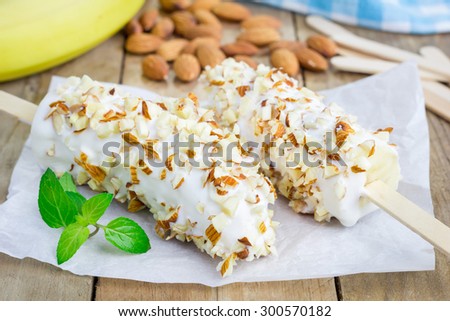 Frozen banana covered with yogurt and almonds