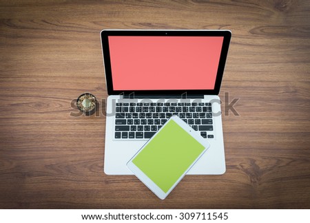 Open laptop with digital tablet and white smartphone. All with isolated screen on old wooden desk