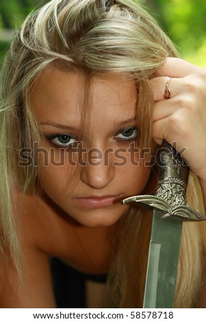 portrait beautiful blonde with dagger in wood