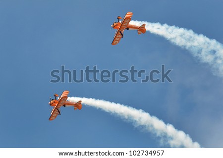 SOUTHPORT, ENGLAND - JULY 23: Two Orange Breitling Bi-planes perform aerobatics and mid air stunts on July 23, 2011 in Southport, England.