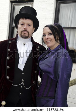WHITBY, UK - NOV 4: A man dressed as Dracula and woman in Victorian clothing celebrating the famous Goff Weekend at Whitby, England on November 4, 2012.