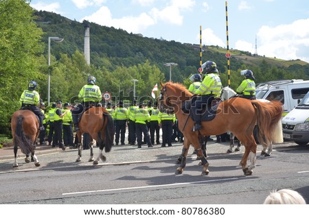 HALIFAX, WEST YORKSHIRE, ENGLAND-JUL 10: Riot Police on horses face demonstrators of the EDL (English Defence League) organised rally on July 10, 2010 in Halifax, West Yorkshire