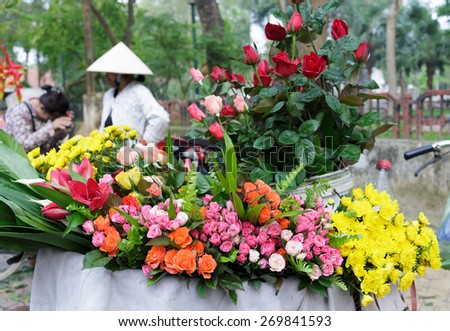 NAMDINH, VIETNAM - APRIL 16, 2015: Unidentified old woman at the flower small market on April 16, 2015 in Namdinh, Vietnam. This is a small market for retail florists and street vendors.