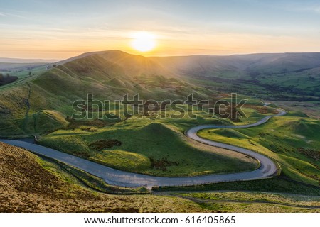 Sunset at Mam Tor in the Peak District with long winding road leading through valley. Stock fotó © 