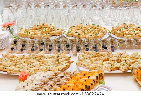 many cold snacks and glasses on buffet table, catering