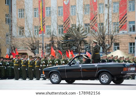 ULAN-UDE, RUSSIA - MAY 9, 2010: The commander standing in a car salute to officers - participants of the parade on annual Victory Day.