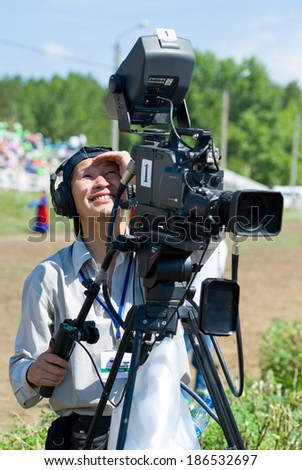 ULAN-UDE, RUSSIA - JULY 17, 2010: An unidentified television cameraman of Buryat State Television and Radio Company works at the opening of the 4th General Session of the World Mongolians Convention.