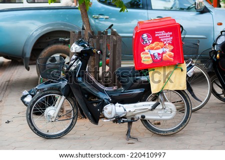 SIEM REAP, CAMBODIA - JUNE 29, 2014: A motorcycle with a box for delivery of KFC food. Kentucky Fried Chicken is a fast food restaurant chain, the second largest one in the world.
