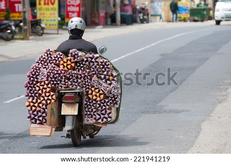DALAT, VIETNAM - JULY 25, 2014: An unidentified motorcyclist drives boxes with aromatic sticks. Motorcyclists in Asia can drive any load on their vehicles, even a refrigerator.