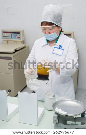 ULAN-UDE, RUSSIA - APR 6, 2010: M. Butukhanova, the chief of the blood storage department, separates plasma out of blood at City Blood Service which makes a promo action for donorship popularization.