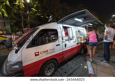 BANGKOK - MARCH 10, 2015: Unidentified people exchange money at a currency exchange van n Khao San Road. It is the main walking street in the tourist area.
