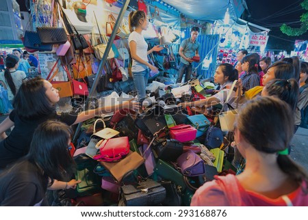 HO CHI MINH - DEC 28, 2014: Unidentified young women buy handbags at a big market in Quang Trung Street. Vietnam is considered a country with rapidly growing economics.