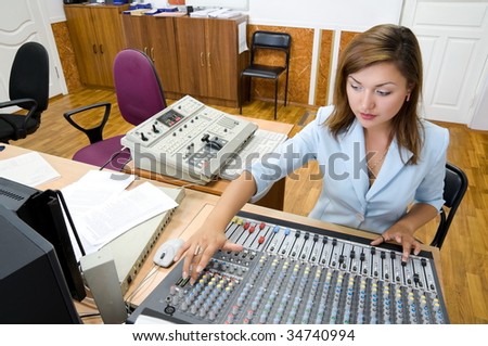 female audio operator at sound mixing console