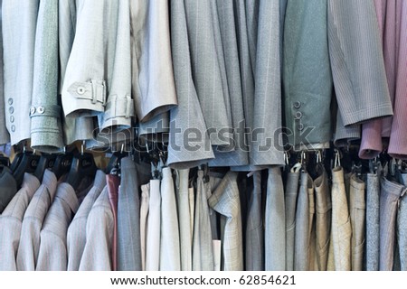 line of mens and ladies clothes hanging in shop