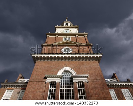 Brick clock tower with dark storm sky at historic Independence Hall National Park in Philadelphia.