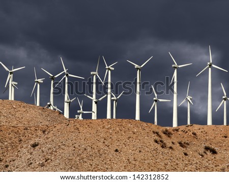 Desert wind mills with thunderstorm sky.