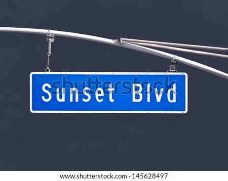 Sunset Blvd overhead street sign with dark storm sky.