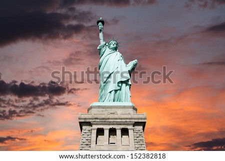 An upshot of the statue of liberty with sunset sky.