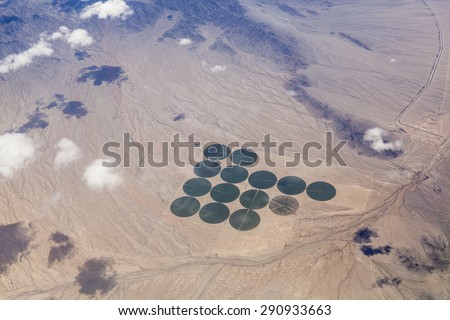 Aerial of green irrigated crop circles in a vast brown expanse of California\'s Mojave Desert.