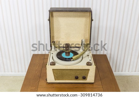 Old box style record player in table.
