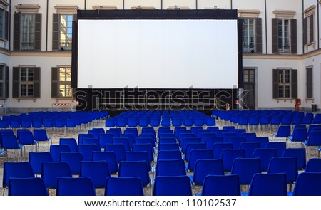View of screen and Empty blue chairs for outdoor cinema