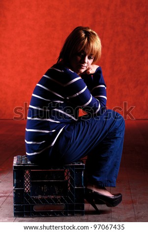 Girl sitting on the stool on red background