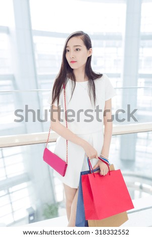 young chinese girl, holding  bag to go inside the mall