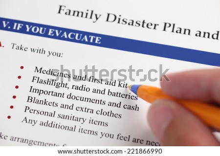 Family Disaster Plan and hand with ballpoint pen. Close-up.