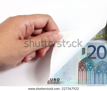 Woman\'s hand turning a white page and 20 euro banknote.